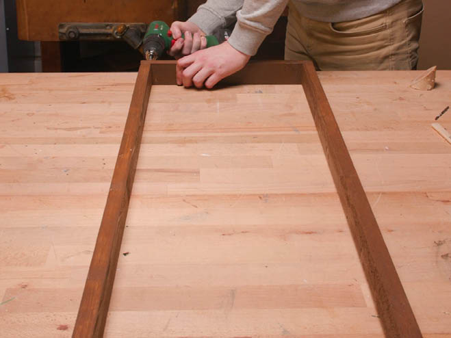 Holzlatten werden zu einem Rahmen zusammengeschraubt