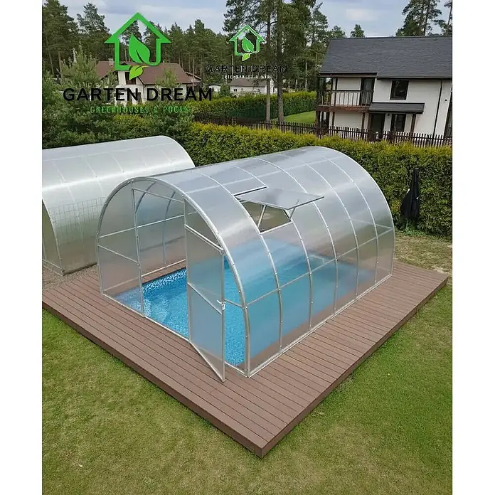 Garten Dream Poolüberdachung Marina - L x B x H: 400 cm x 300 cm x 2.100 mm - Gewölbte, transparente Poolüberdachung mit silbernem Rahmen über blauem Pool auf Holzterrasse.