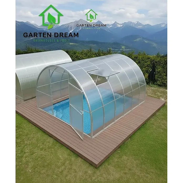 Garten Dream Poolüberdachung Marina - L x B x H: 400 cm x 300 cm x 2.100 mm - Transparente, gewölbte Poolüberdachung mit Silberrahmen über blauem Pool auf Holzdeck. Offene Luke und Tür sichtbar.