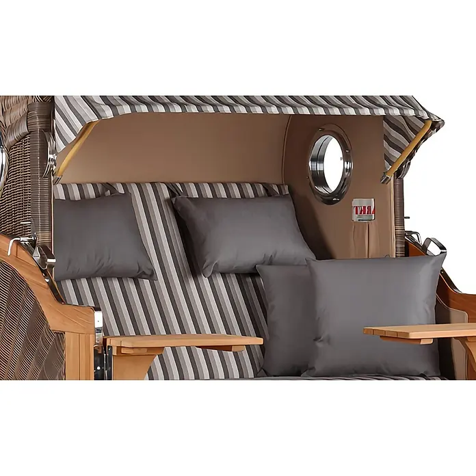 Mr. Deko Strandstuhl Strandkorb Düne Grande Bullauge Teak PE Grey Dessin 545 - 1 Stk., Teakholz. Polyrattan, Rückenlehne verstellbar, PE Grey - Innenansicht eines Strandkorbs mit gestreifter Polsterung, grauen Kissen, Holztischen und Bullaugen.