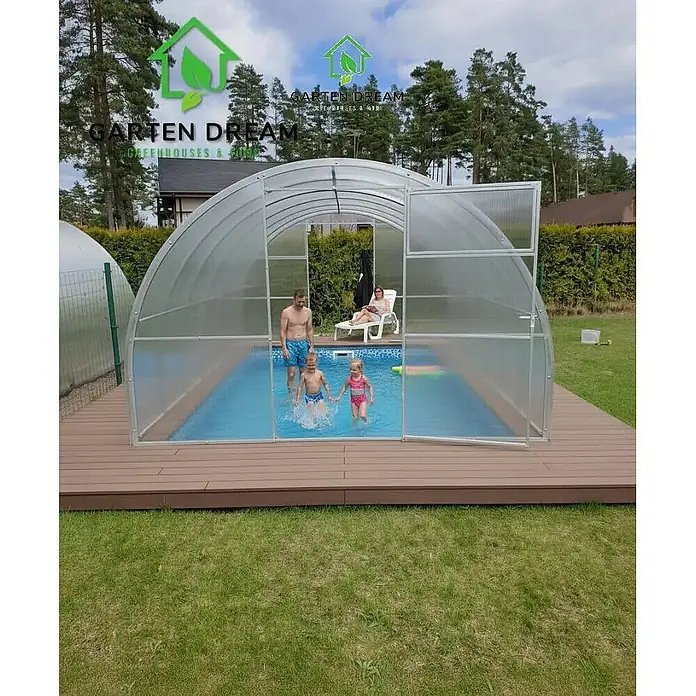 Garten Dream Poolüberdachung - L x B x H: 1.000 x 300 x 200 cm - Gewölbte Poolüberdachung aus transluzenten Platten und braunem Terrassenboden, eine Familie genießt das Schwimmen.
