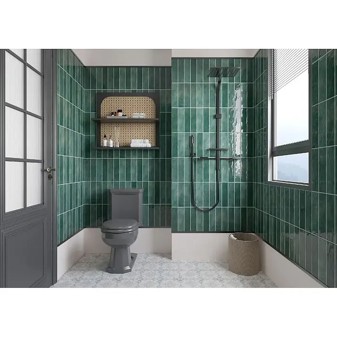 Wandfliese Santorini - 7,5 x 30 cm, Dark Green, Glänzend - Modernes Badezimmer mit glänzenden grünen Vertikalfliesen, einer grauen Toilette und einer schwarzen Duscharmatur.