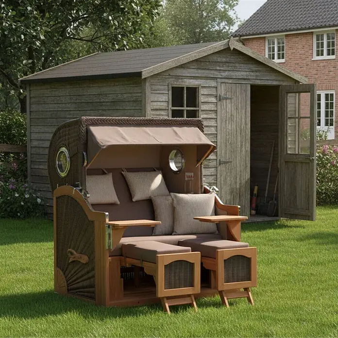 Mr. Deko Strandstuhl Strandkorb Düne Grande Bullauge Teak PE Grey Dessin 534 - 1 Stk., Teakholz. Polyrattan, Rückenlehne verstellbar, PE Grey - Brauner Strandkorb aus Holz und Geflecht mit braunen Polstern und gestreiften Kissen, mit ausziehbaren Fußteilen, in einem Garten.
