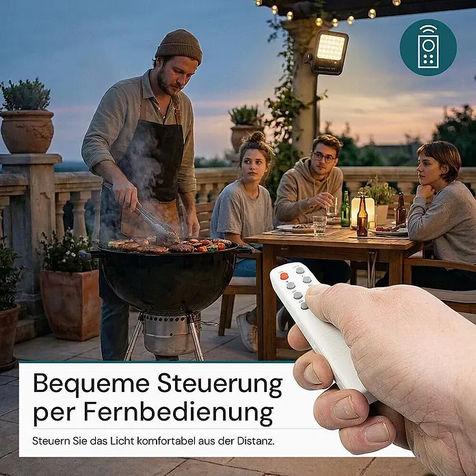 Luxula Solar-Außenwandleuchte LED Solarstrahler - 15 W, L x B x H: 24,9 x 23,2 x 4,8 cm, Schwarz, IP65, 1.650 lm - Outdoor-Flutlicht beleuchtet eine Terrasse mit grillenden und speisenden Personen. Eine Hand hält die Fernbedienung im Vordergrund.