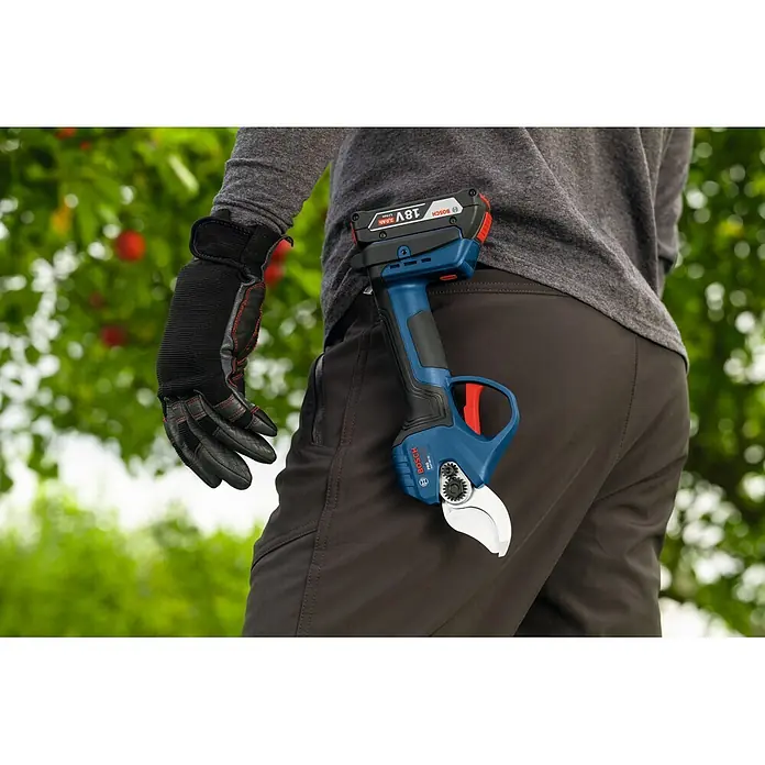 Bosch Akku-Astschere GGP18V-32 - 18 V, Max. Aststärke: 32 mm - Bosch blau-schwarze Akku-Astschere mit 18V-Akku, an Arbeitshose geklemmt, behandschuhte Hand daneben, im Garten.