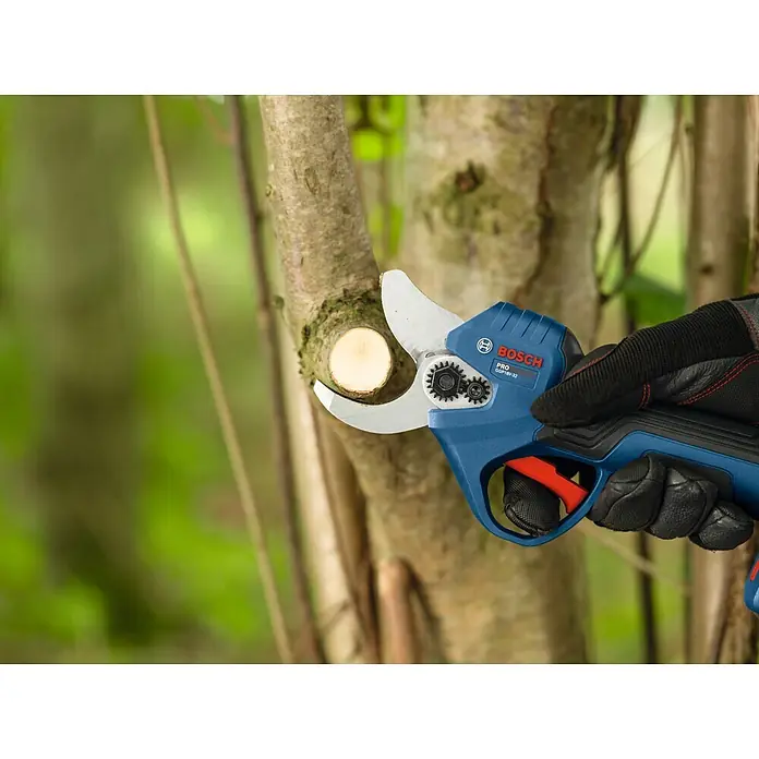 Bosch Akku-Astschere GGP18V-32 - 18 V, Max. Aststärke: 32 mm - Blauer und schwarzer Bosch Pro Astschneider mit silbernen Klingen, von einer behandschuhten Hand gehalten, schneidet einen Ast.