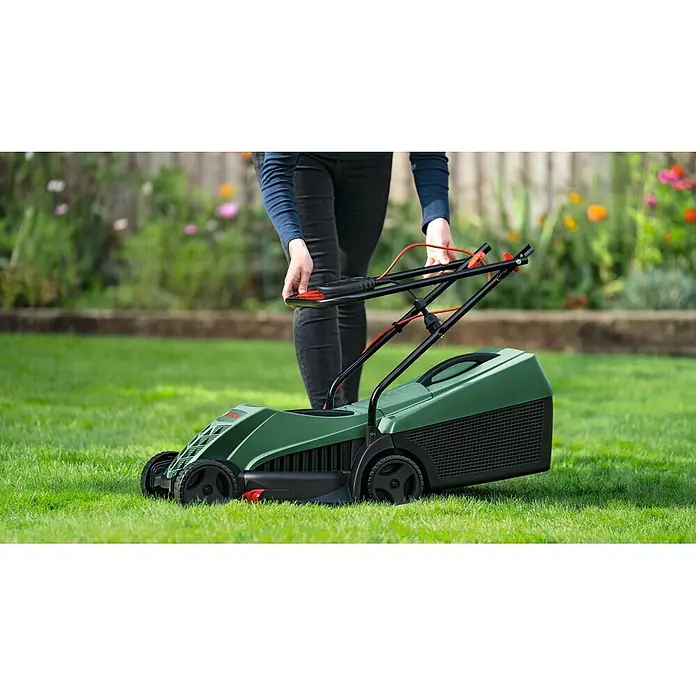 Bosch Elektro-Rasenmäher EasyRotak 32-235 - 1.200 W, Schnittbreite: 32 cm - Grüner Rasenmäher mit schwarzen und roten Akzenten, von einer Person bedient.