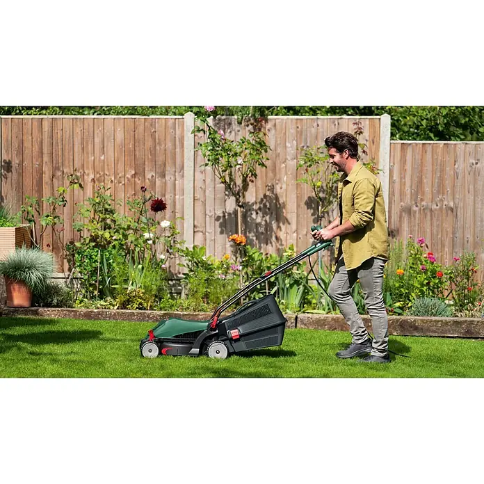Bosch Universal Elektro-Rasenmäher UniversalRotak 37-570 - 1.400 W, Schnittbreite: 37 cm - Mann mäht Rasen mit einem grün-schwarzen Elektromäher im Garten.