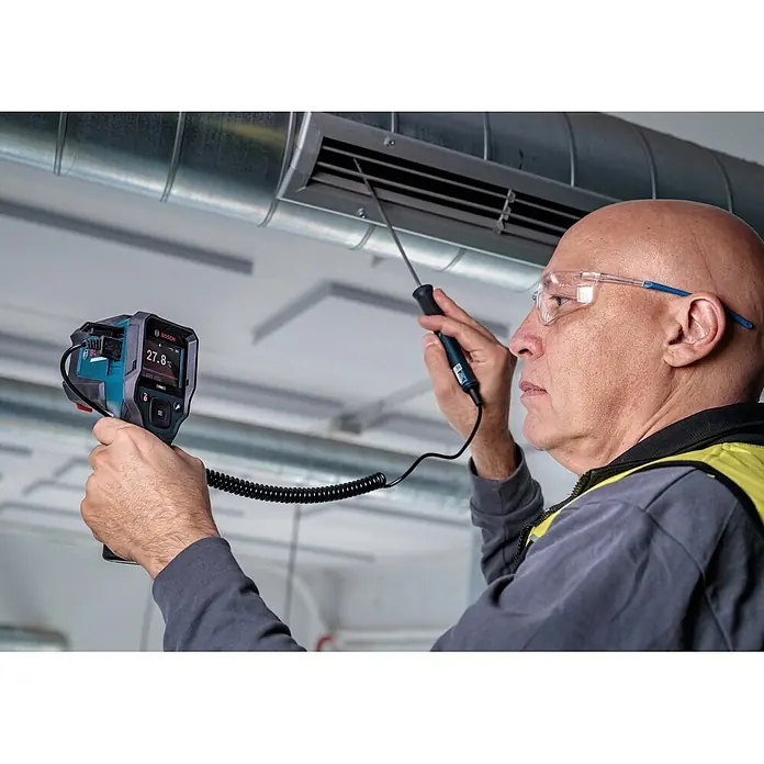Bosch Professional Thermodetektor Pro GIS12V-800-16 - Messbereich Temperatur: -40 °C - 800 °C, Mit Batterien - Mann misst einen Lüftungskanal mit einer schwarz-blauen Bosch-Wärmebildkamera und einer Sonde.