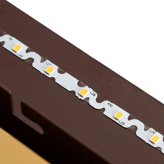 Lucande Wandleuchte World - L x B x H: 4,6 x 60 x 30 cm, braun / rost - Weißes LED-Band mit gelben Lichtern auf einer dunkelbraunen, texturierten Oberfläche montiert.