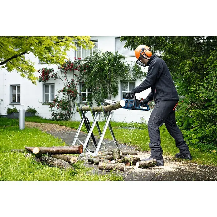 Bosch Professional AMPShare 18V Akku-Kettensäge GKE18V-30 - 18 V, Ohne Akku, Schwertlänge: 30 cm - Eine Person mit Schutzausrüstung schneidet mit einer blau-schwarzen Kettensäge einen Holzstamm auf einem Sägebock.