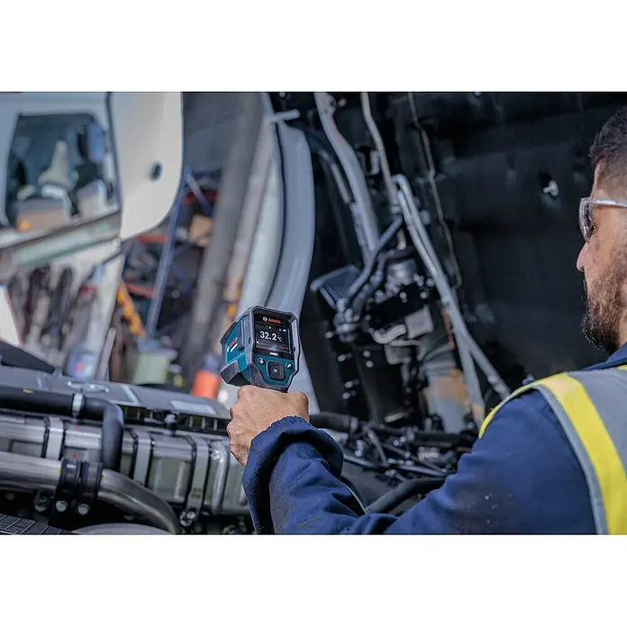 Bosch Professional Thermodetektor Pro GIS12V-800-16 - Messbereich Temperatur: -40 °C - 800 °C, 1 Akku - Person inspiziert einen Schwerlastmotor mit einer blau-schwarzen Bosch Wärmebildkamera, die 32,2°C anzeigt.