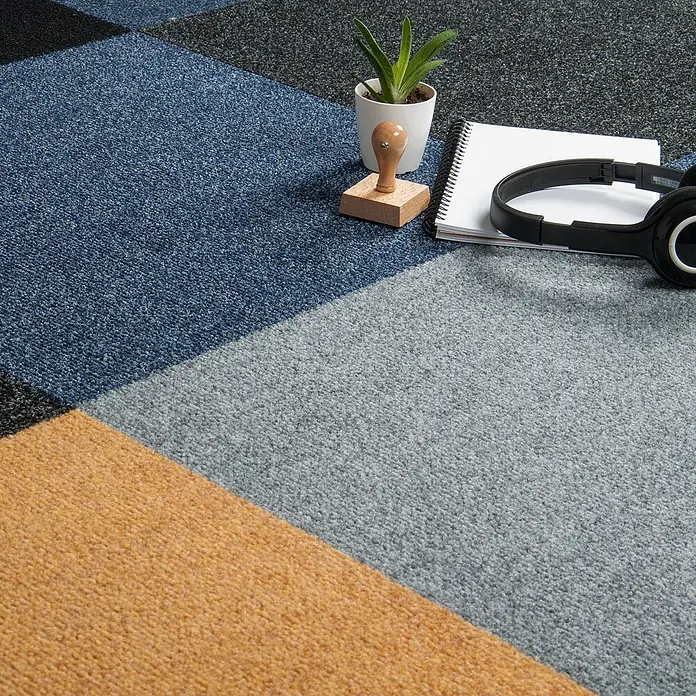 Bricoflor Teppichfliese - Breite: 50 cm, Nadelfilz, Polypropylen, grau - Geometrische Teppichfliesen in Blau, Grau, Schwarz und Orange mit Büromaterialien wie Pflanze und Kopfhörern.