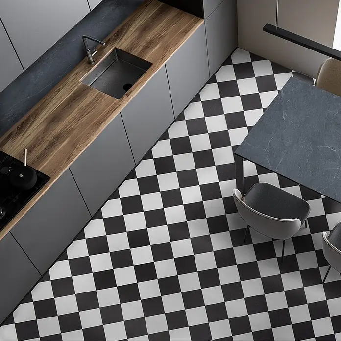 Vinylboden CV-Belag - 1.300 x 100 cm, Damier 019D - Draufsicht auf eine moderne L-förmige Küche mit grauen Schränken, Holztheke, Spüle, Kochfeld, Esstisch und Stühlen.