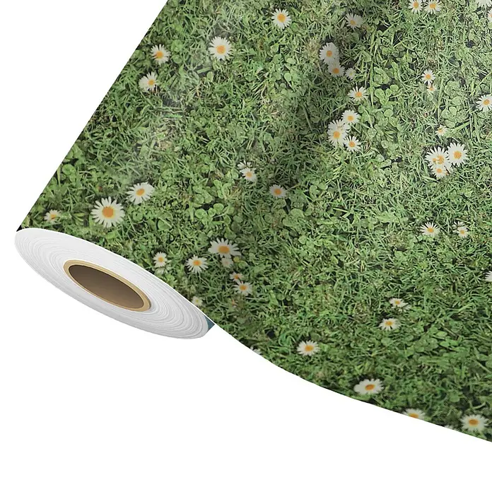 Vinylboden CV-Belag - 1.900 x 200 cm, Daisies - Tapetenrolle mit lebhaftem Gras- und Gänseblümchenmuster, teilweise abgerollt.