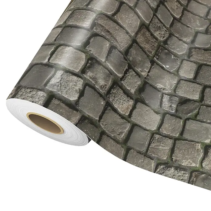 Vinylboden CV-Belag - 50 x 100 cm, Cobble - Rolle selbstklebender Folie mit realistischem grauen Kopfsteinpflastermuster und grünem Moos, teilweise abgerollt, um das Design zu zeigen.