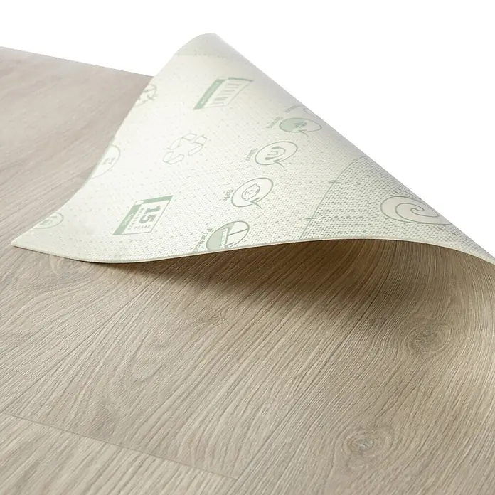 Vinylboden CV-Belag - 1.100 x 100 cm, Albus 3 - Weiße Unterlage mit grünen Symbolen, von hellem Holzlaminatboden zurückgerollt.