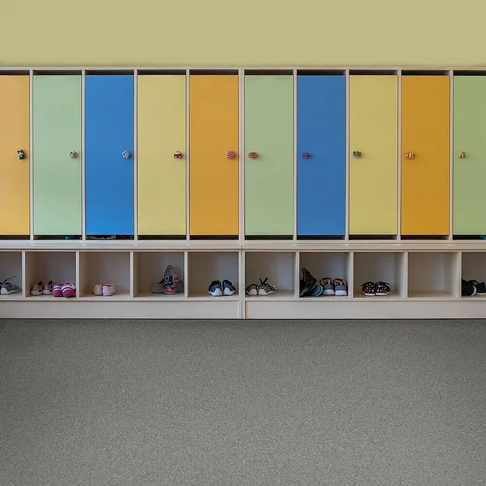 Vinylboden CV-Belag - 250 x 200 cm, Mira 690D - Bunte Kindergarderobe mit Tier- und Autoknöpfen und Schuhfächern darunter. Verschiedene Kinderschuhe sind in den Fächern aufbewahrt.
