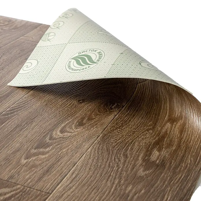 Vinylboden CV-Belag - 1.400 x 200 cm, Bartek-Eiche - Teilweise ausgerollter dunkelbrauner Bodenbelag in Holzoptik, der seine hellgrüne Unterseite mit einem Umweltzeichen zeigt.