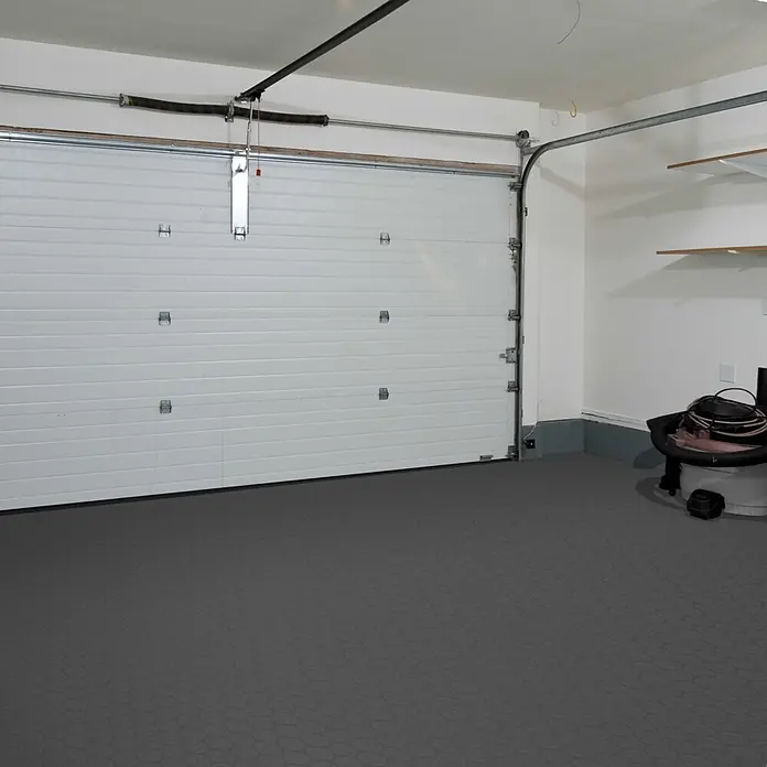 Vinylboden CV-Belag - 500 x 200 cm, Anthrazit, Fairplay - Dunkelgrauer Garagenboden mit subtilem sechseckigem Muster, in einer Garage installiert.
