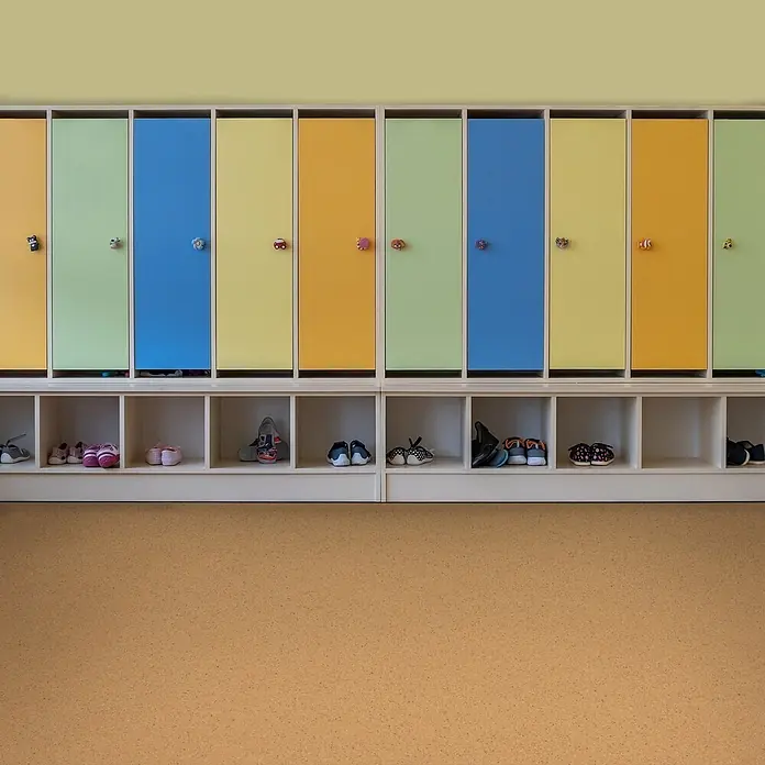 Vinylboden CV-Belag - 50 x 200 cm, Mira 330M - Ein farbenfroher Kinder-Spindschrank mit Schuhfächern. Er hat blaue, grüne, gelbe und orangefarbene Türen mit lustigen, geformten Griffen.