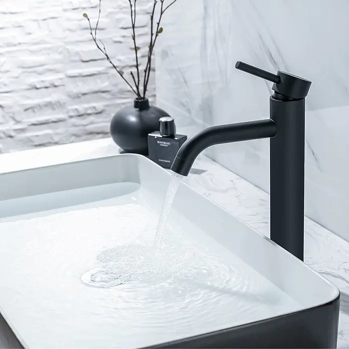 LOMAZOO Waschtischarmatur LMZ-CARDANO - Schwarz - Matt schwarzer Badarmatur, der Wasser in ein elegantes, rechteckiges Waschbecken in Weiß und Schwarz gießt.