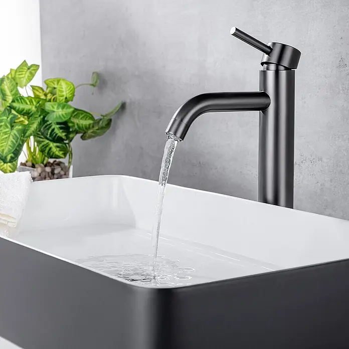 LOMAZOO Waschtischarmatur LMZ-JASMIN - Gunmetal - Mattschwarzer moderner Wasserhahn, der Wasser in ein elegantes schwarz-weißes Aufsatzwaschbecken gießt.