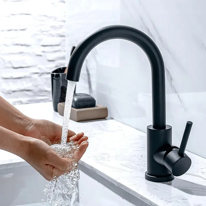 LOMAZOO Waschtischarmatur JUNO - Schwarz - Matt schwarzer Wasserhahn mit Wasser, das in geschöpfte Hände in einem weißen Waschbecken läuft.