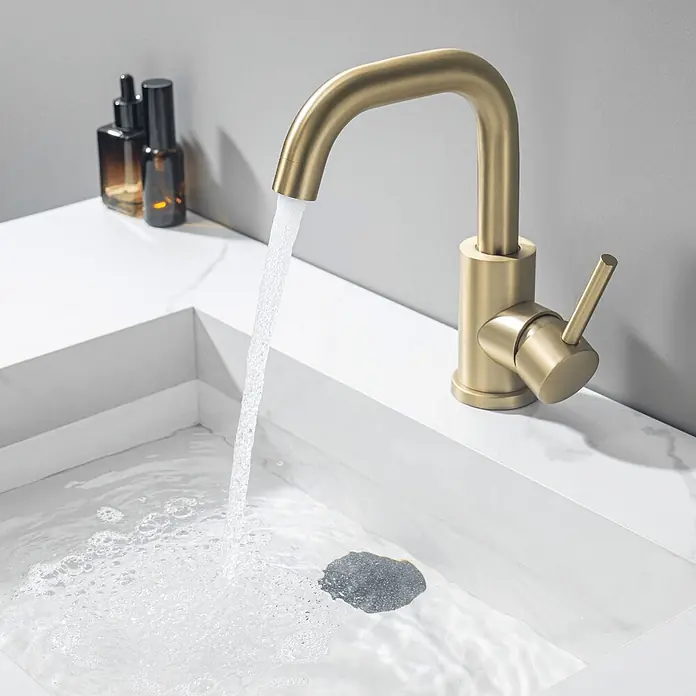 LOMAZOO Waschtischarmatur LMZ-STELLAR - Gold - Mattgoldener Wasserhahn mit fließendem Wasser in ein weißes Waschbecken.