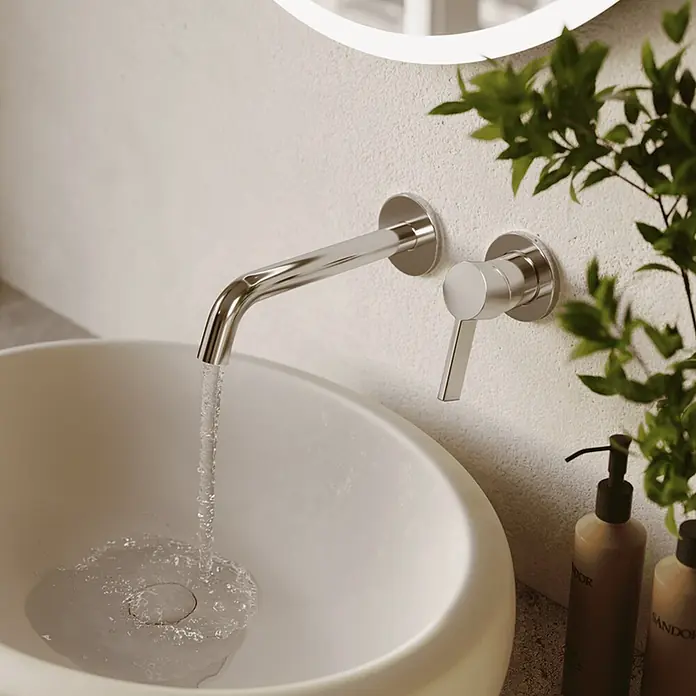 LOMAZOO Waschtischarmatur LMZ-KEPLER - Chrom - Verchromte Wandarmatur mit fließendem Wasser in ein weißes Waschbecken.