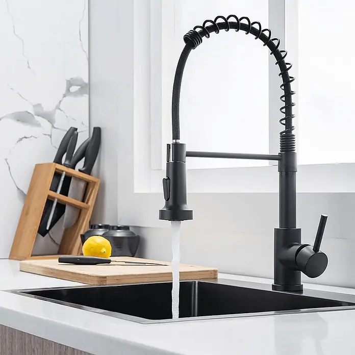 LOMAZOO Spültischarmatur LMZ-SAPPHIRE - Zwart - Schwarze Federdesign-Küchenarmatur spendet aktiv Wasser in ein dunkles Spülbecken in moderner Küchenumgebung.