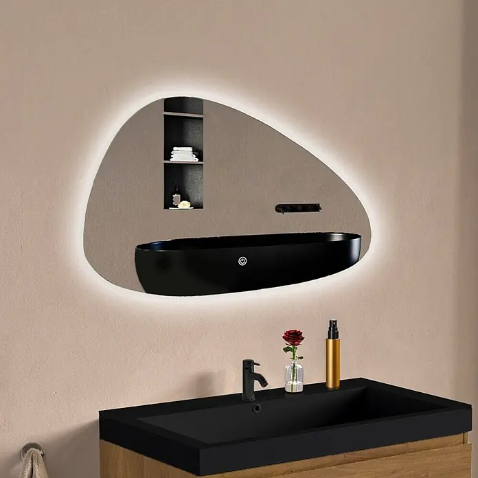 LOMAZOO Lichtspiegel LMZ-BILBAO - Glänzend weiß - Unregelmäßig geformter LED-Badspiegel, der ein schwarzes Waschbecken und einen Wasserhahn widerspiegelt, über einem Holzwaschtisch montiert.