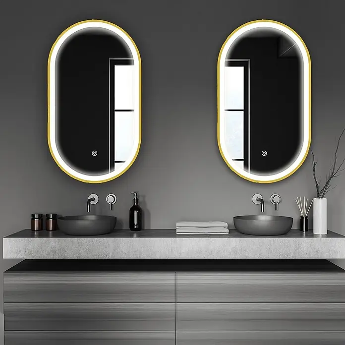 LOMAZOO Lichtspiegel LMZ-BERLIN - Gold - Zwei ovale Badezimmerspiegel mit gelben Rahmen und beleuchteten Kanten, über einem Doppelwaschtisch mit grauen Aufsatzwaschbecken.