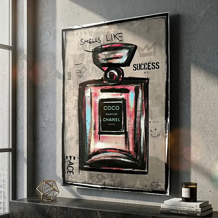 Dotcomcanvas Decopanel - Smells Like Success, B x H: 58 x 90 cm - Gerahmter Kunstdruck einer stilisierten Chanel No. 5 Parfümflasche im Pop-Art-Stil mit „SMELLS LIKE SUCCESS N°5“-Text, in einem modernen Raum.