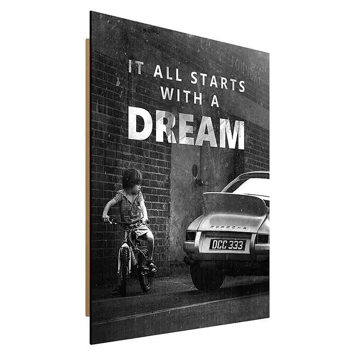 Dotcomcanvas Decopanel - It all starts with a dream, B x H: 40 x 50 cm - Schwarz-weißes Poster mit Kind auf Rad vor Porsche und Spruch 'IT ALL STARTS WITH A DREAM'.