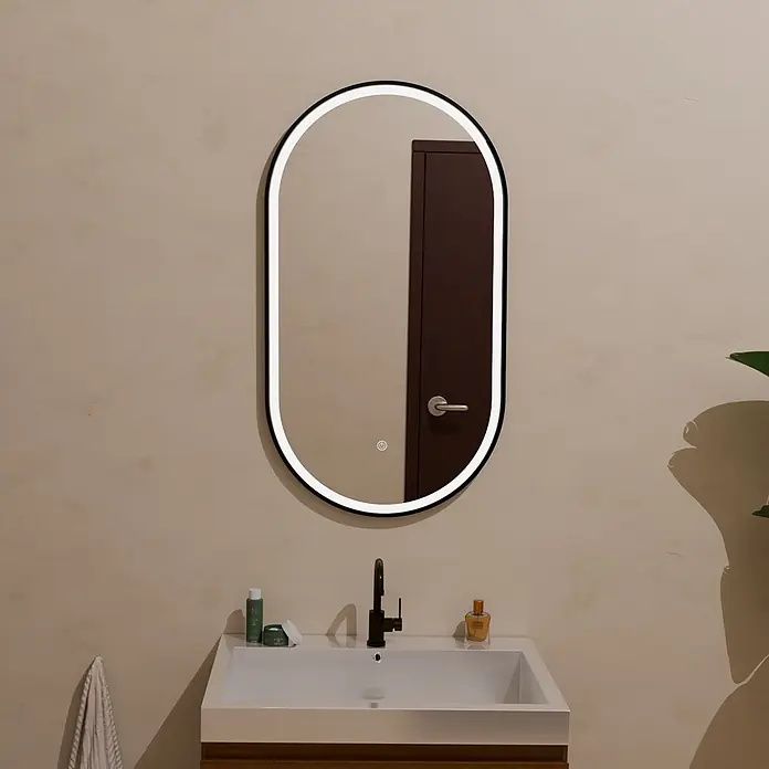 LOMAZOO Lichtspiegel LMZ-LEIPZIG - Schwarz - Ovaler LED-Badezimmerspiegel mit schwarzem Rahmen, beleuchtet über einem Waschbecken.