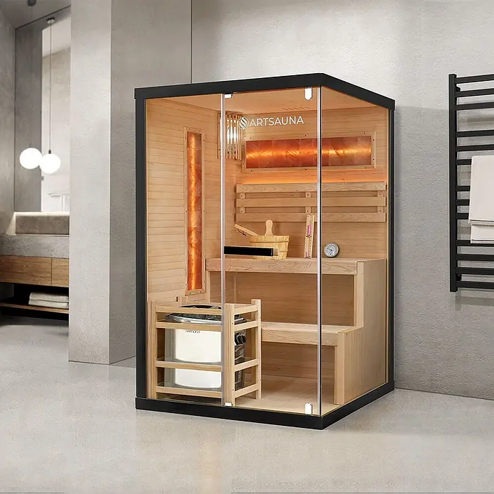 Artsauna Elementsauna Vantaa - L x B x H: 120 x 120 x 190 cm - Moderne Indoor-Saunakabine mit schwarzem Rahmen, Glasfront, hellem Holzinterieur, Ofen und warmen Salzlampenakzenten im modernen Badezimmer.