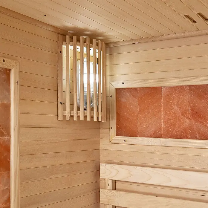 Artsauna Elementsauna Vantaa - L x B x H: 120 x 120 x 200 cm - Ecke eines hellen Holzsauna-Innenraums mit Lattenrostabdeckung, orangefarbenen Salzplatten und Holzbank.
