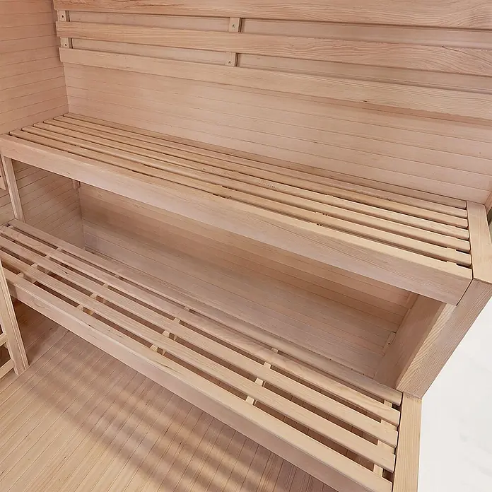 Artsauna Elementsauna Vantaa - L x B x H: 140 x 175 x 200 cm - Zweistufige Saunabänke aus hellem Holz mit Lattenauflagen in einer Saunakabine.