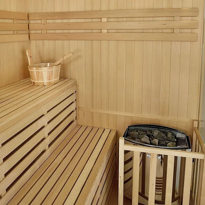 Artsauna Elementsauna Espoo - L x B x H: 150 x 150 x 200 cm - Sauna-Innenraum mit hellen Holzbänken, passendem Eimer und Kelle sowie einem steinbefüllten Elektroofen.