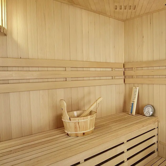 Artsauna Elementsauna Espoo - L x B x H: 150 x 150 x 200 cm - Heller Holzsauna-Innenraum mit Holzeimer, Kelle, Thermometer und Hygrometer auf hellen Holzbänken.