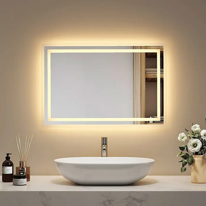 Emke Lichtspiegel Dimlite LM04 - 40 x 60 cm - Rechteckiger LED-Badezimmerspiegel mit beleuchtetem Rand, über einem weißen Waschbecken und Chromarmatur.
