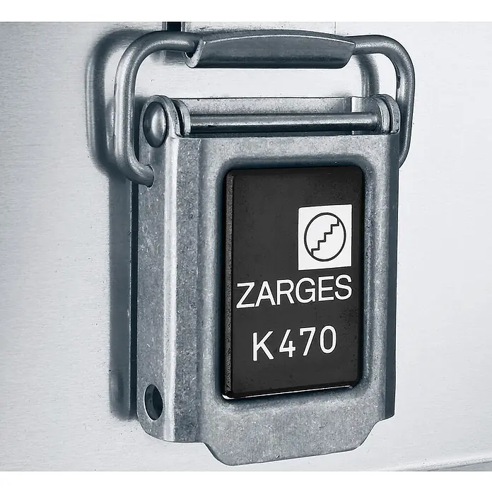 Zarges Aufbewahrungsbox Transportkiste K470 Plus Oberteil 600x400x410mm 73l -  - Nahaufnahme eines gebürsteten Metallverschlusses mit schwarzem Etikett 'ZARGES K470' und Logo, Teil eines robusten Aluminiumbehälters.
