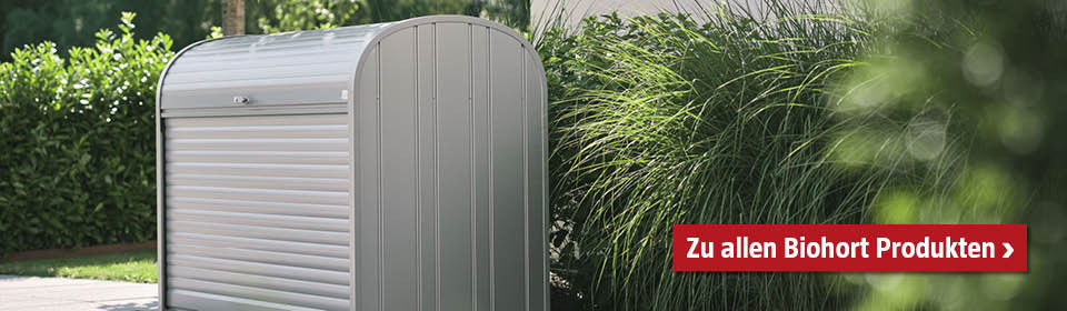 Große Biohort Gartenbox in der Einfahrt, dahinter Gräser in den Beeten
