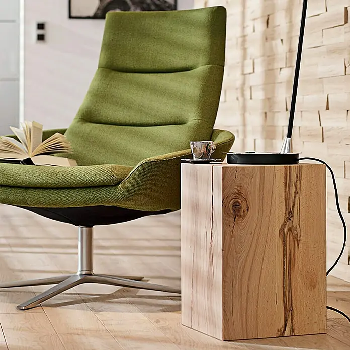 Noblewood Massivholzblock - Buche, 30 x 30 x 45 cm - Ein stilvoller, olivgrüner Sessel mit einem Holzhocker als Beistelltisch, der eine Tasse und eine Lampe trägt, für eine gemütliche Leseecke.