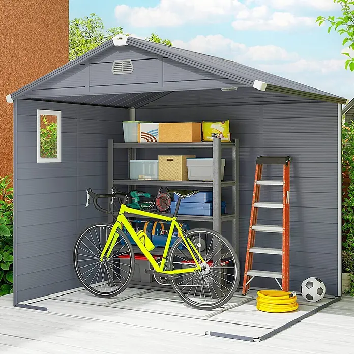Outsunny Gerätehaus - Außenbreite inkl. Dachüberstand: 240 cm, Außentiefe inkl. Dachüberstand: 190 cm, Aluminium, Dunkelgrau - Grauer Gartenschuppen mit Giebeldach, beherbergt ein Fahrrad, Regale mit verschiedenen Gegenständen, eine Leiter, Schlauch und Fußball.