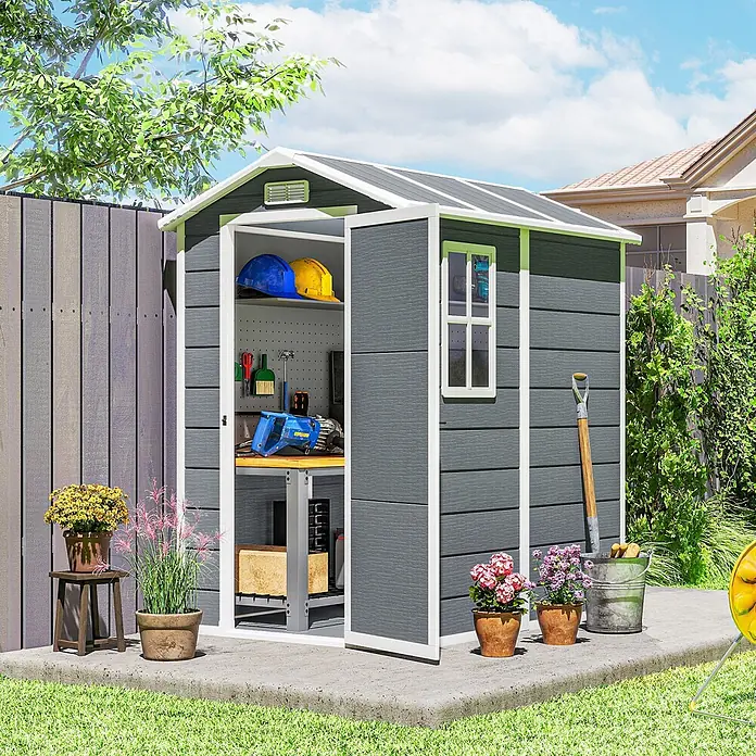 Outsunny Gerätehaus - Außenbreite inkl. Dachüberstand: 131 cm, Außentiefe inkl. Dachüberstand: 186 cm, Aluminium, Grau - Dunkelgrauer Geräteschuppen aus Verbundstoff mit weißem Rand, geöffnet mit Werkzeugen und Helmen, auf Betonplatte im Garten.
