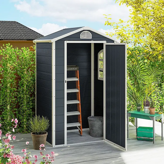 Outsunny Gerätehaus - Außenbreite inkl. Dachüberstand: 134 cm, Außentiefe inkl. Dachüberstand: 104 cm, Aluminium, Dunkelgrau - Dunkelgraues Gartenhaus mit weißem Besatz auf einer Holzterrasse, zeigt eine offene Tür mit Leiter und Eimer im Inneren.