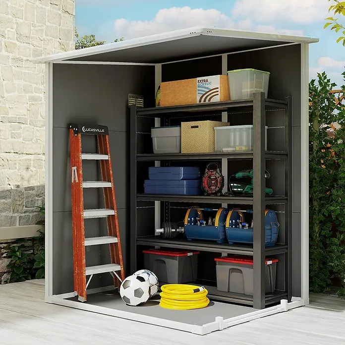 Outsunny Gerätehaus - Außenbreite inkl. Dachüberstand: 149 cm, Außentiefe inkl. Dachüberstand: 122 cm, Kunststoff, Grau - Outdoor-Lagerschuppen mit dunkelgrauen Paneelen, weißem Rahmen und schwarzem Regal, bestückt mit Werkzeugen, Kisten und Sportgeräten.