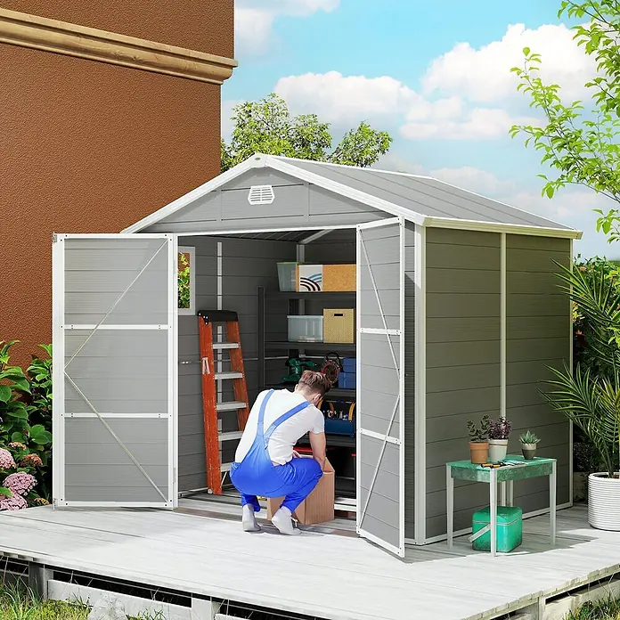 Outsunny Gerätehaus - Außenbreite inkl. Dachüberstand: 240 cm, Außentiefe inkl. Dachüberstand: 190 cm, Aluminium, Hellgrau - Graues Metall-Gartenhaus mit Doppeltüren, eine Person ordnet Regale mit Werkzeugen und Aufbewahrungsboxen.